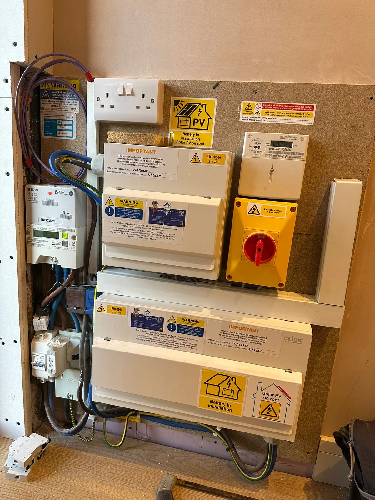 man in brown and white plaid dress shirt and yellow hard hat holding black and orange